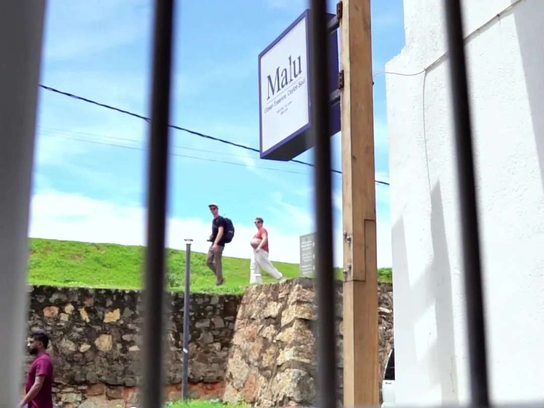 La muralla de Galle Fort vista desde una ventana de Malu, con el cartel de la casa colgado en la calle